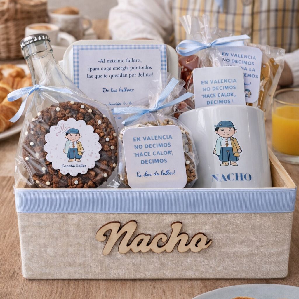 Desayuno fallero a domicilio en Valencia con taza personalizada, rosquilletas, dulces artesanales y botella de zumo presentado en caja con nombre grabado.