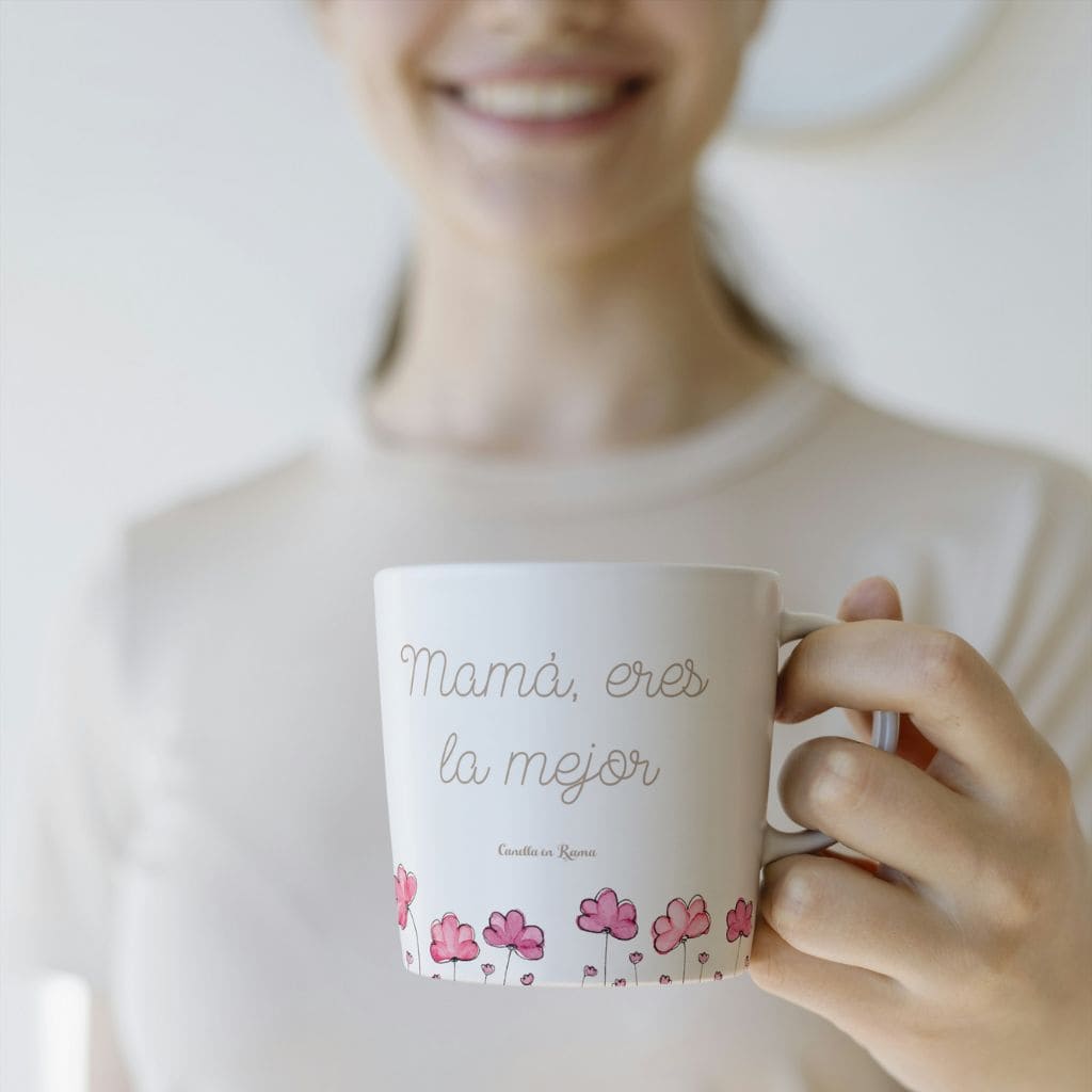 Persona sonriendo sosteniendo en su mano la taza mamá eres la mejor de Canella en Rama