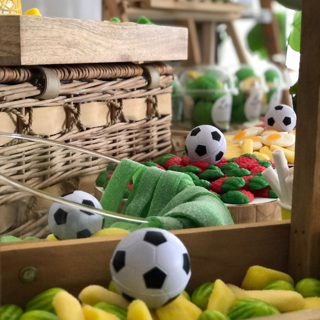 Balones de fútbol pequeños sobre platos con chuches