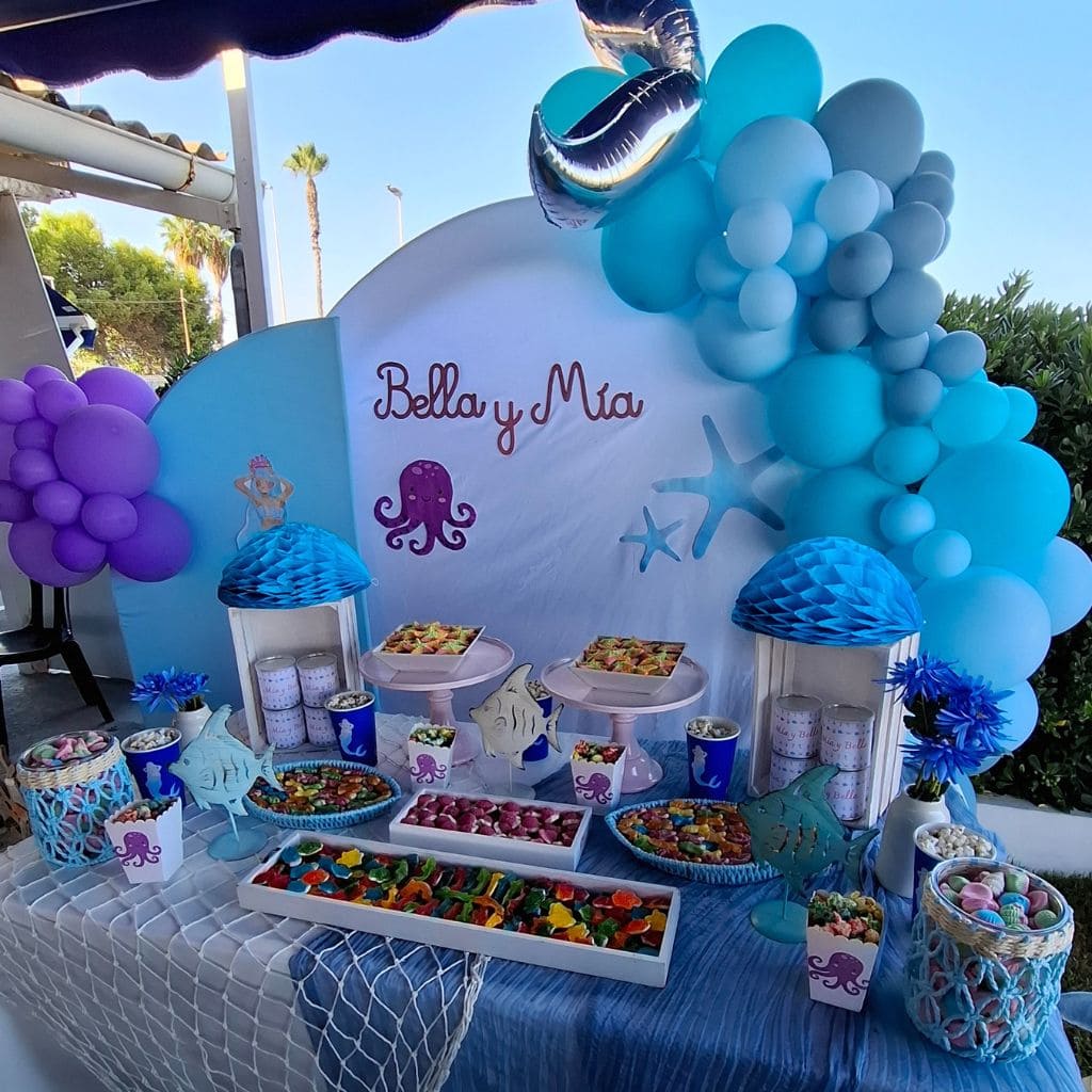 Foto general de la mesa dulce de sirena en la que se puede observar la decoración de mar y el color violeta, azul y gris de la mesa