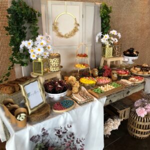 Mesa dulce para boda en tonos dorados y detalles florales, con variedad de chuches y dulces para invitados