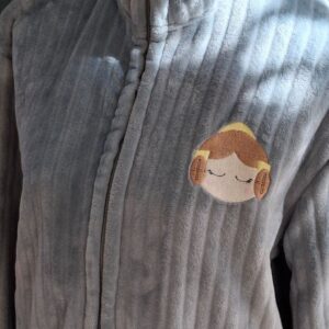 Chaqueta fallera gris con la cara de la fallera bordada en el lado izquierdo