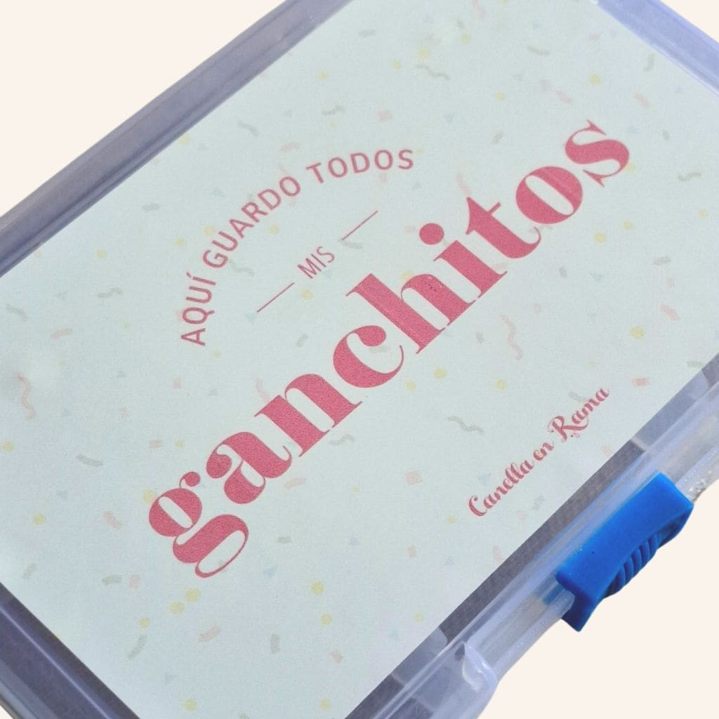 Vista en ángulo de la caja de ganchitos falleros, mostrando su etiqueta divertida y cierre seguro en azul.