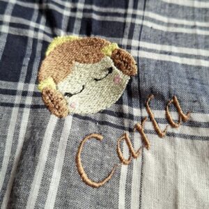 Pañuelo fallero de cuadros con bordado de fallera y nombre "Carla", detalle en tela clásica valenciana.