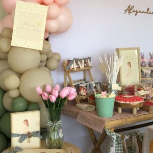 Mesa dulce con variedad de chuches, destacando las fresas de goma con hojas verdes, nubes de colores pastel y otras golosinas organizadas en recipientes. Los botes de cristal personalizados añaden un toque especial al montaje