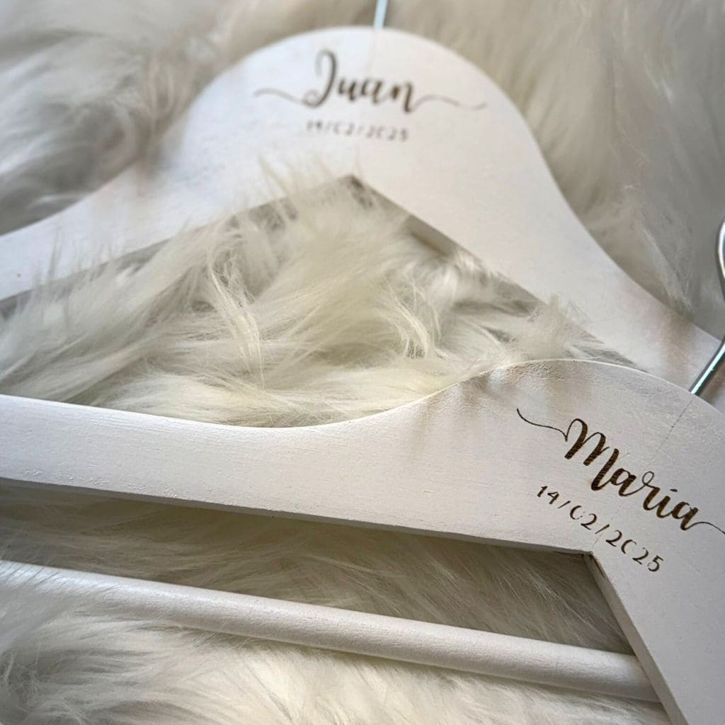 Detalle de perchas personalizadas para novios con grabado de nombres y fecha del día de la boda.