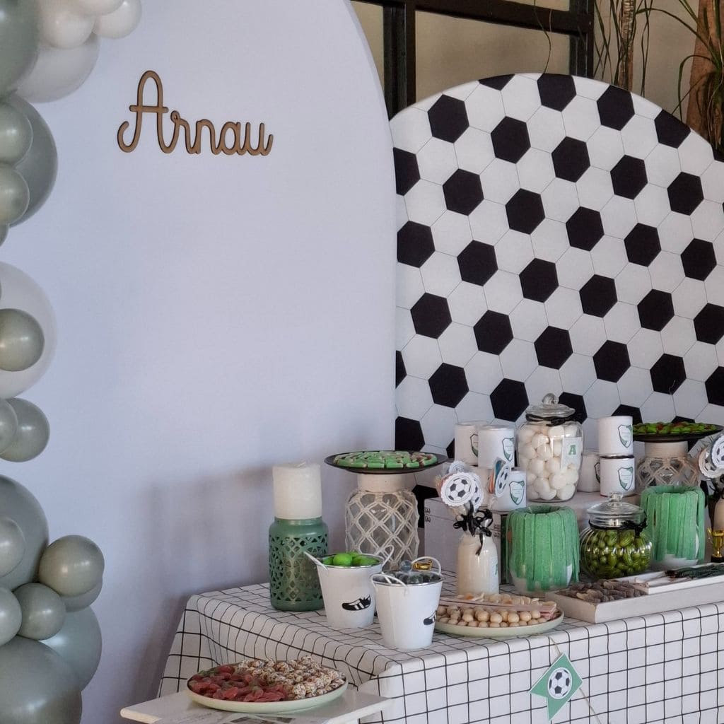 Mesa dulce para comunión con chuches, decoración futbolera y detalles personalizados.