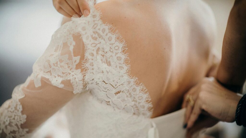 hermano ayudando a novia a ponerse el vestido con el regalo de Canella en Rama
