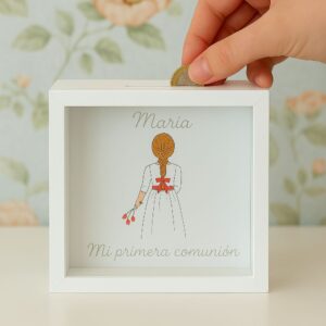 Mano introduciendo moneda en hucha personalizada de comunión para niña