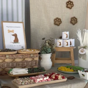 Detalle de mesa dulce de comunión con temática de perro salchicha, decorada con golosinas y tarros personalizados sobre fondo de lino y huellas decorativas.
