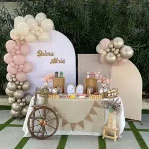 Mesa dulce en tonos beige, rosa empolvado y dorado perlado para comunión o bautizo, con decoración natural y elegante.