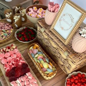 Candy bar con temática de conejo y presentación cuidada de chuches en bandejas de madera y recipientes decorativos