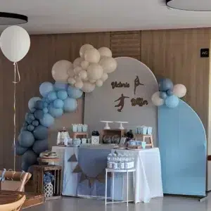 Mesa dulce de gimnasia artística decorada en tonos azul y beige con detalles elegantes y siluetas deportivas.