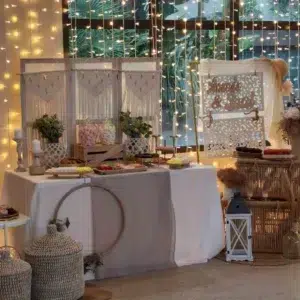 Mesa dulce estilo Ibiza decorada con luces cálidas y dulces artesanales para eventos bohemios