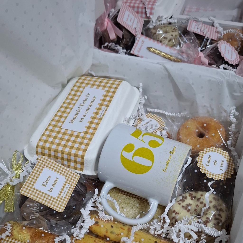 Detalle de desayuno de cumpleaños de Canella en Rama con galletas, bizcochos, etiqueta “Eres lo más” y taza personalizada con el número 65.